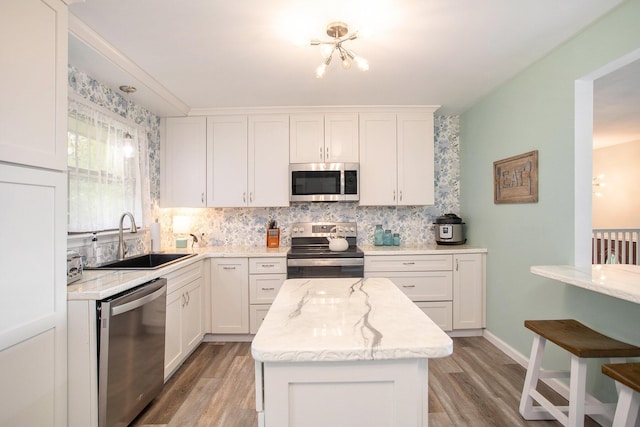 7920 8 1/2 Mile Rd, Ceresco, MI 49033 - kitchen with stainless steel appliances, light wood-type flooring, backsplash, and white cabinets