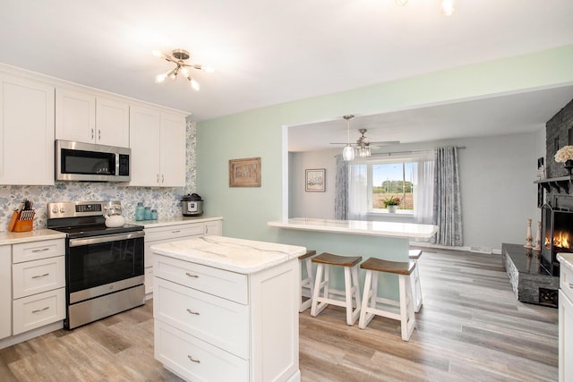 7920 8 1/2 Mile Rd, Ceresco, MI 49033 - kitchen with stainless steel appliances, tasteful backsplash, light wood finished floors, and white cabinetry