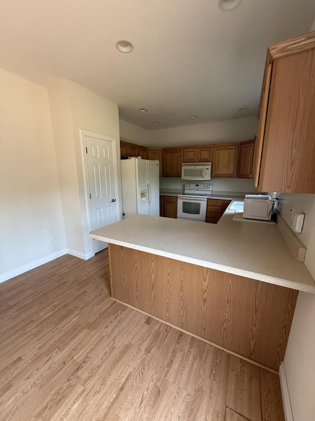 5798 Wacker Dr, Stevensville, MI 49127 - kitchen with white appliances, light wood finished floors, a peninsula, brown cabinetry, and recessed lighting