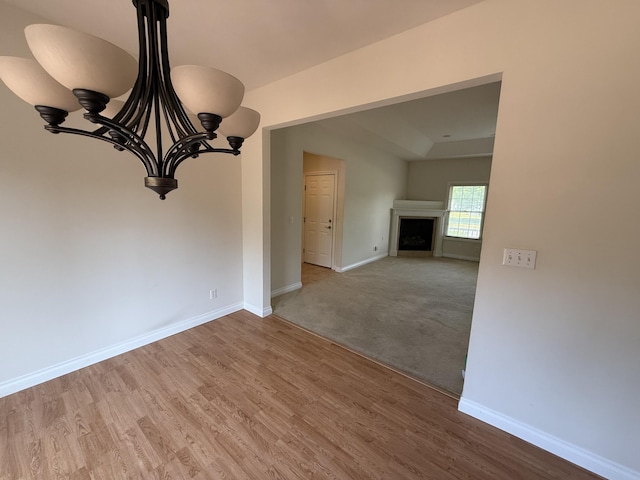 5798 Wacker Dr, Stevensville, MI 49127 - unfurnished room with a chandelier, wood finished floors, and a fireplace
