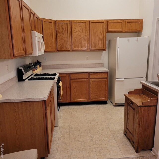 22865 Woodcreek Dr, Taylor, MI 48180 - kitchen featuring white appliances, brown cabinets, light countertops, and light flooring
