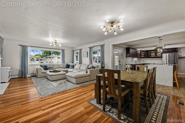 49775 Keycove St, Chesterfield, MI 48047 - dining space with a chandelier, light wood-type flooring, and a baseboard heating unit