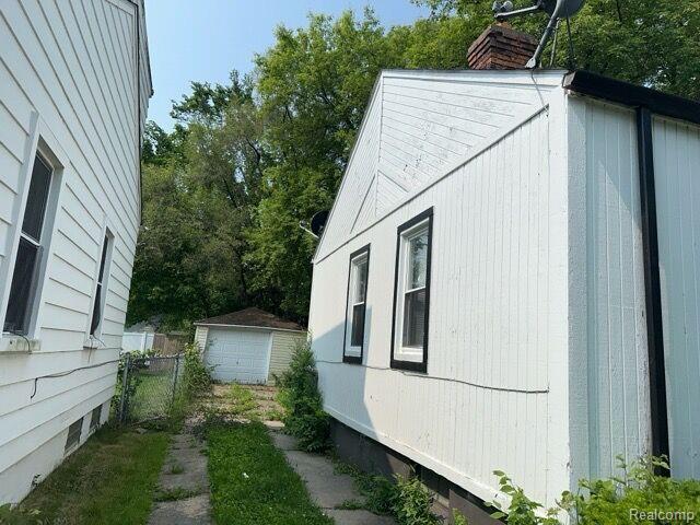 19670 Mccormick St, Detroit, MI 48224 - view of home's exterior with an outdoor structure and a chimney