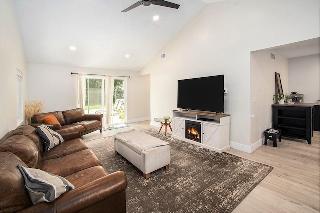 701 E Alice St, Whitehall, MI 49461 - living room with a ceiling fan, light wood-style floors, high vaulted ceiling, recessed lighting, and a warm lit fireplace