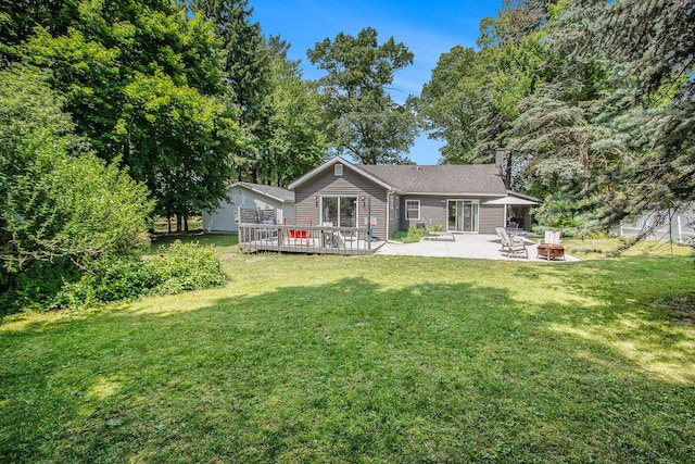 701 E Alice St, Whitehall, MI 49461 - back of property featuring an outdoor fire pit, a yard, a chimney, and a wooden deck
