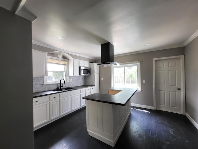 23077 Piper Ave, Eastpointe, MI 48021 - kitchen with dark countertops, stainless steel microwave, island range hood, decorative backsplash, and white cabinetry