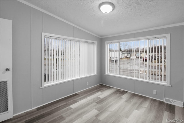 39500 W Warren Rd, Canton, MI 48187 - empty room featuring vaulted ceiling, a textured ceiling, ornamental molding, and wood finished floors