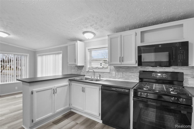 39500 W Warren Rd, Canton, MI 48187 - kitchen with black appliances, a peninsula, light wood-style flooring, tasteful backsplash, and a textured ceiling