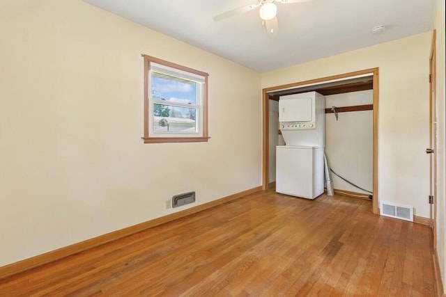 3202 Niles Buchanan Rd, Buchanan, MI 49107 - unfurnished bedroom with stacked washer / drying machine, light wood-style flooring, a ceiling fan, and a closet