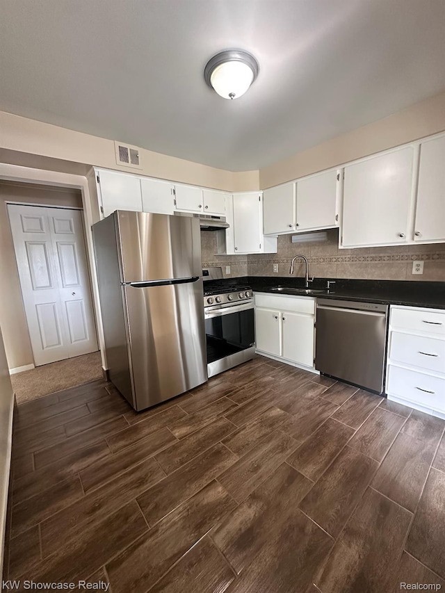 490 N Fox Hills Dr N Unit 2, Bloomfield Hills, MI 48304 - kitchen featuring stainless steel appliances, dark wood-style flooring, dark countertops, white cabinetry, and tasteful backsplash