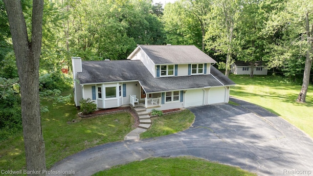 3485 Burrus Ct, Ortonville, MI 48462 - view of front facade featuring covered porch, driveway, a chimney, a garage, and a front yard