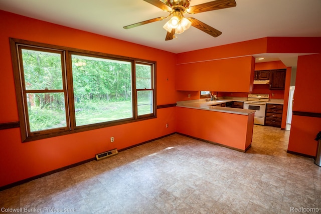 3485 Burrus Ct, Ortonville, MI 48462 - kitchen featuring electric range, a peninsula, under cabinet range hood, a ceiling fan, and light countertops