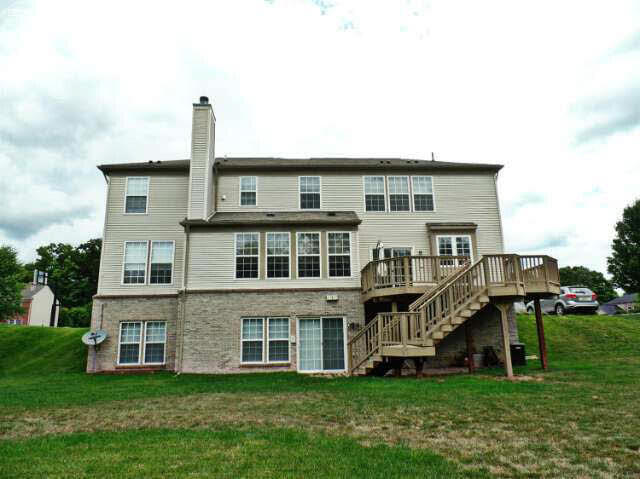 6296 Moonstone Dr, Grand Blanc, MI 48439 - rear view of property with stairway, a deck, a chimney, and a lawn