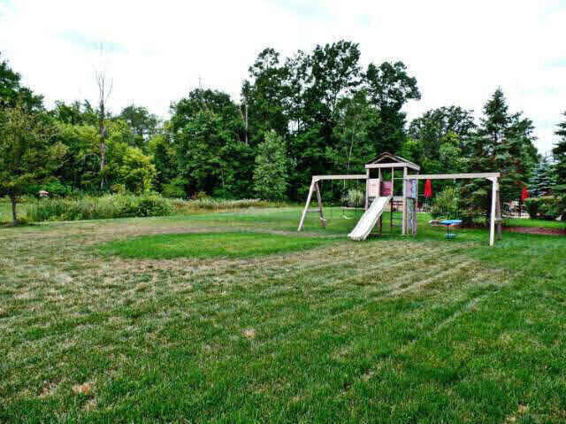 6296 Moonstone Dr, Grand Blanc, MI 48439 - view of green lawn with a playground