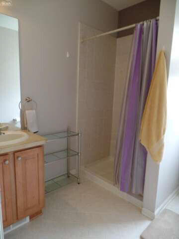 6296 Moonstone Dr, Grand Blanc, MI 48439 - full bathroom with tiled shower, vanity, and tile patterned floors