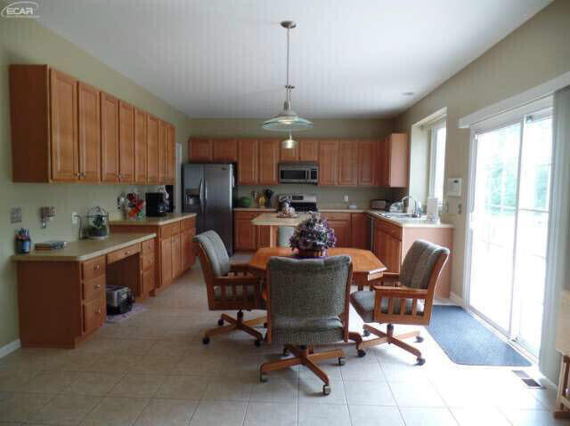 6296 Moonstone Dr, Grand Blanc, MI 48439 - kitchen with stainless steel appliances, light countertops, and hanging light fixtures