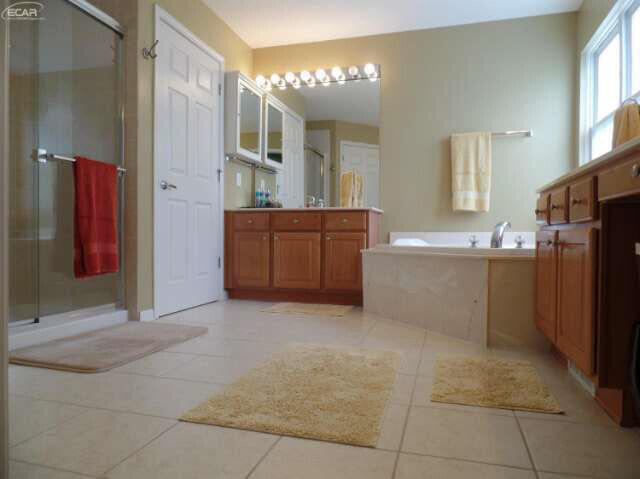 6296 Moonstone Dr, Grand Blanc, MI 48439 - full bath with vanity, tile patterned floors, and a stall shower