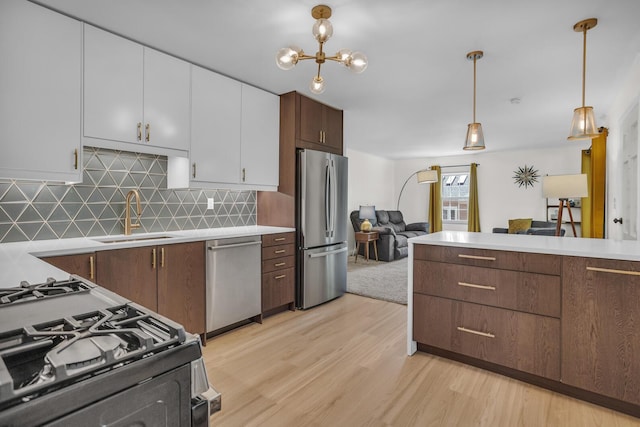 1603 Park Rd, Jackson, MI 49203 - kitchen with stainless steel appliances, light countertops, light wood-type flooring, backsplash, and pendant lighting