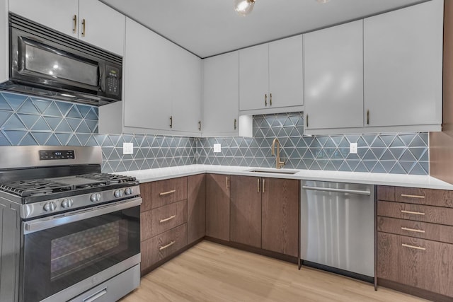 1603 Park Rd, Jackson, MI 49203 - kitchen with stainless steel appliances, light countertops, light wood-type flooring, and white cabinetry