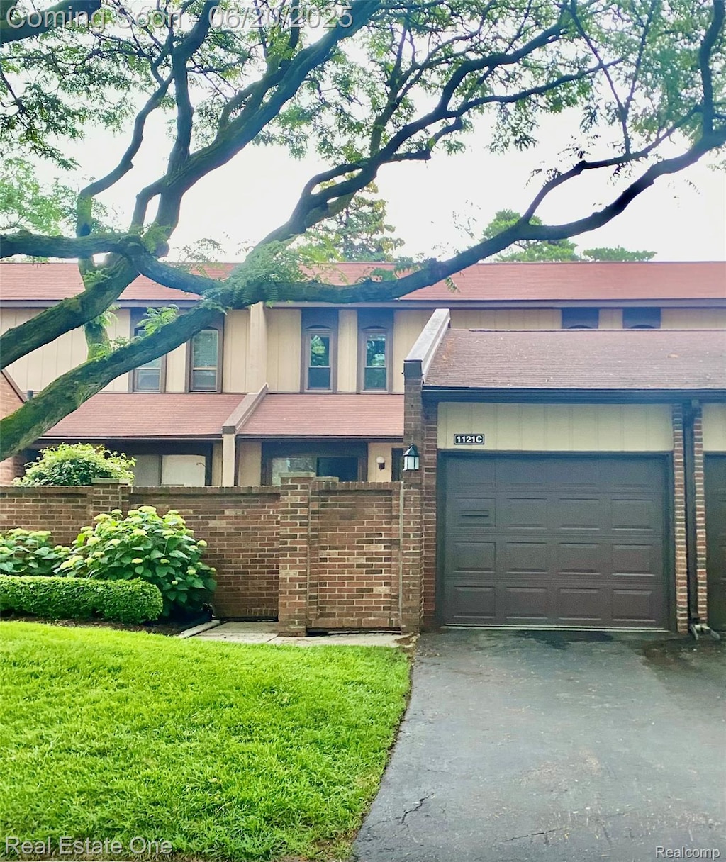 1121 Kirts Blvd Unit C, Troy, MI 48084 - view of front of home featuring driveway, a garage, and brick siding