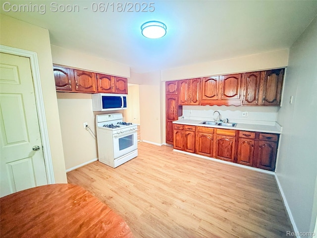 32303 Glen St, Westland, MI 48186 - kitchen with white appliances, light wood-style flooring, light countertops, and brown cabinets