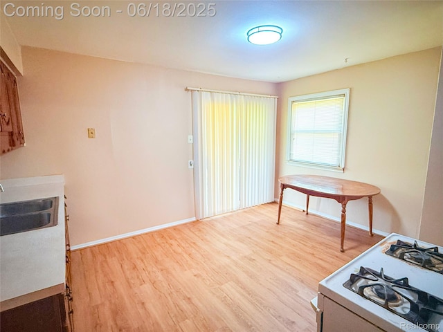 32303 Glen St, Westland, MI 48186 - kitchen featuring white gas range, wood finished floors, and light countertops