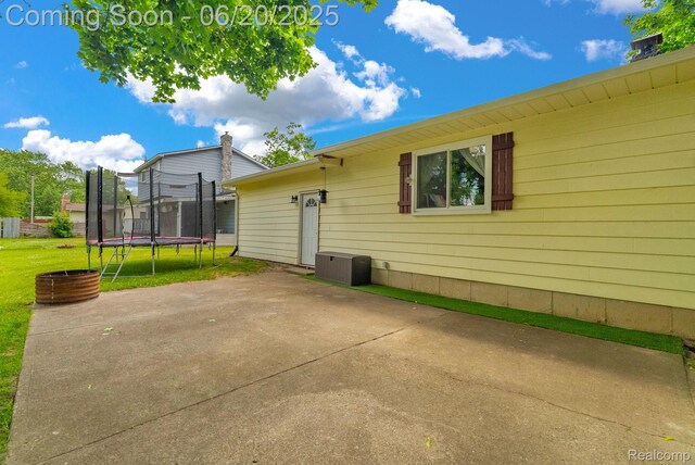 312 Airport Dr, Holly, MI 48442 - back of house with a trampoline and a patio