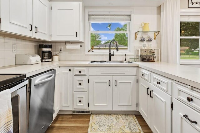 3108 Kim St, Saint Joseph, MI 49085 - kitchen featuring appliances with stainless steel finishes, light countertops, white cabinetry, tasteful backsplash, and dark wood-style floors