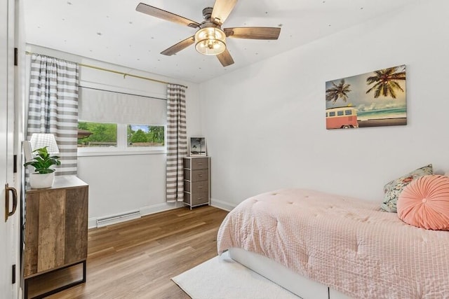 3108 Kim St, Saint Joseph, MI 49085 - bedroom with wood finished floors, a baseboard heating unit, and a ceiling fan