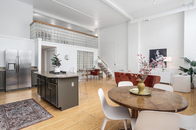 2843 E Grand Blvd Unit 4, Detroit, MI 48211 - dining space with a towering ceiling, light wood-style floors, beam ceiling, and stairway