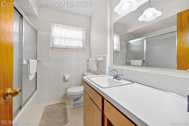 6514 Maple St, Dearborn, MI 48126 - full bathroom featuring tile patterned floors, vanity, tile walls, enclosed tub / shower combo, and wainscoting