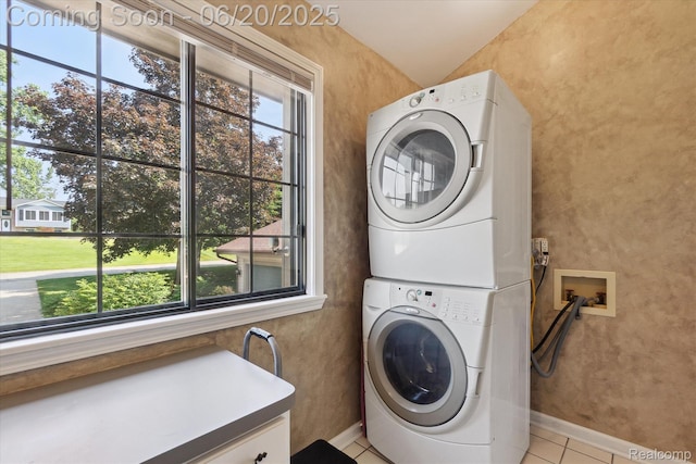 2386 Sherlock Trl, Highland, MI 48356 - laundry room with stacked washer / dryer, cabinet space, and light tile patterned floors
