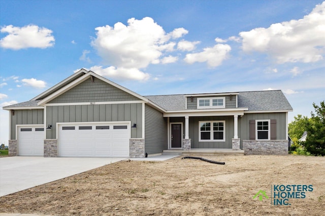1827 Stratford Ln NW, Grand Rapids, MI 49534 - craftsman-style home featuring stone siding, an attached garage, board and batten siding, and covered porch