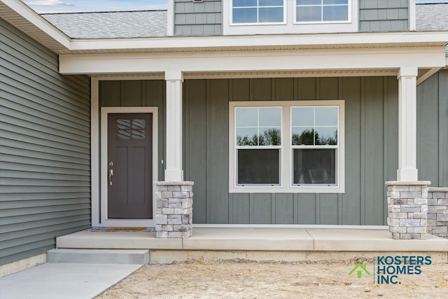 1827 Stratford Ln NW, Grand Rapids, MI 49534 - doorway to property with board and batten siding, a shingled roof, and stone siding