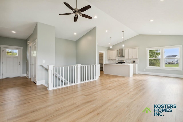1827 Stratford Ln NW, Grand Rapids, MI 49534 - unfurnished living room featuring lofted ceiling, plenty of natural light, light wood-type flooring, ceiling fan, and recessed lighting