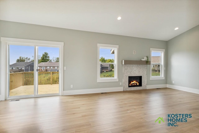 1827 Stratford Ln NW, Grand Rapids, MI 49534 - unfurnished living room featuring a glass covered fireplace, light wood-style floors, and recessed lighting