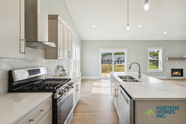1827 Stratford Ln NW, Grand Rapids, MI 49534 - kitchen with stainless steel appliances, wall chimney exhaust hood, light wood-type flooring, light stone countertops, and tasteful backsplash