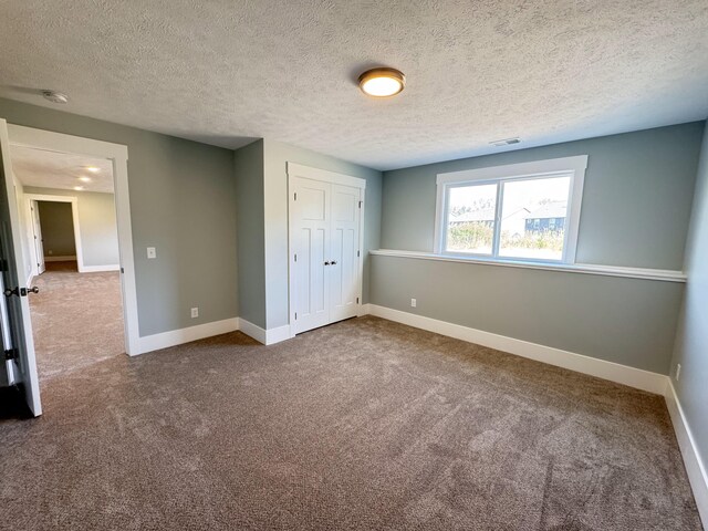 1827 Stratford Ln NW, Grand Rapids, MI 49534 - unfurnished bedroom featuring dark carpet, a textured ceiling, and a closet