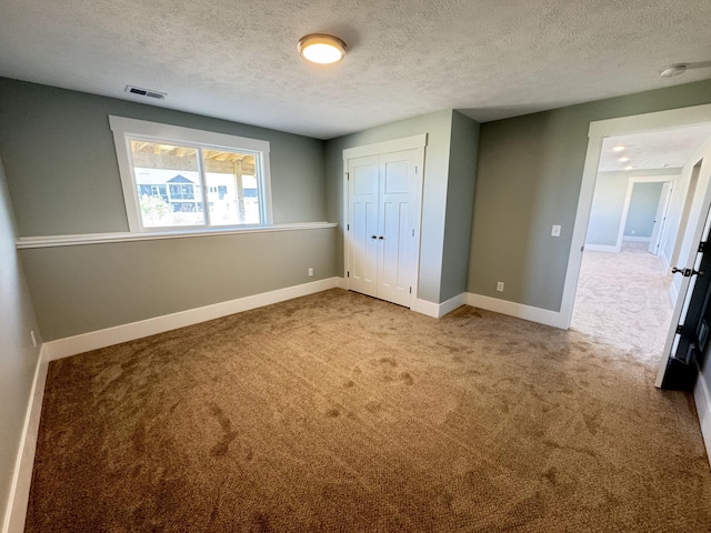 1827 Stratford Ln NW, Grand Rapids, MI 49534 - unfurnished bedroom with carpet, a textured ceiling, and a closet