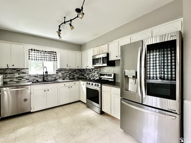 8464 Keitha Dr, Lambertville, MI 48144 - kitchen with stainless steel appliances, dark countertops, decorative backsplash, and white cabinets