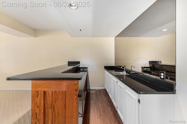 5387 Bristol Parke Dr, Clarkston, MI 48348 - kitchen featuring dark countertops, a peninsula, white cabinets, dark wood finished floors, and recessed lighting