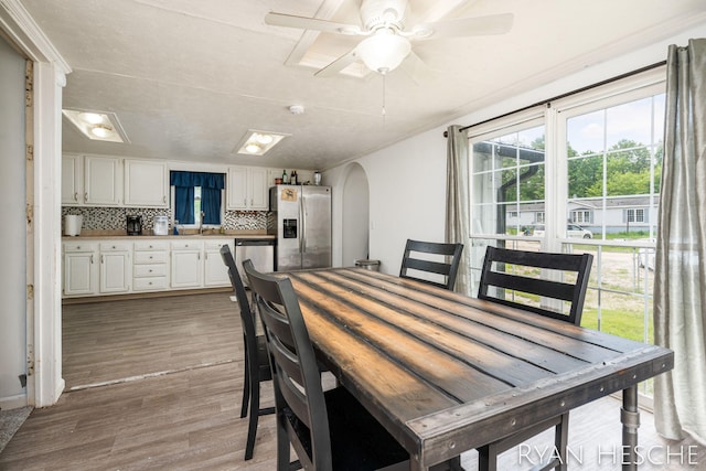 10340 Kartz Rd, Greenville, MI 48838 - dining space with light wood-style flooring, arched walkways, and a ceiling fan