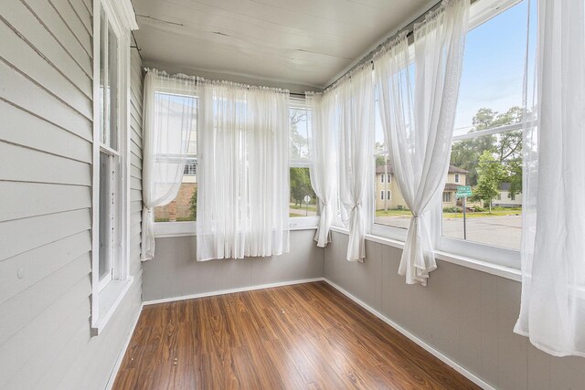 390 W Muskegon Ave, Muskegon, MI 49440 - unfurnished sunroom with baseboards and wood finished floors
