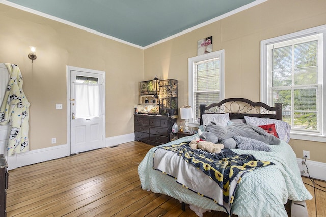 390 W Muskegon Ave, Muskegon, MI 49440 - bedroom with multiple windows, crown molding, and wood-type flooring