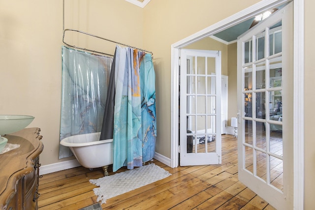 390 W Muskegon Ave, Muskegon, MI 49440 - full bath featuring hardwood / wood-style flooring, a freestanding bath, ornamental molding, vanity, and a shower with curtain
