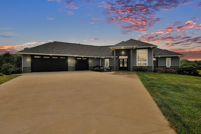 7074 S Ainger Rd, Olivet, MI 49076 - prairie-style home featuring a garage, stone siding, driveway, a front lawn, and french doors