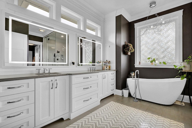 7074 S Ainger Rd, Olivet, MI 49076 - bathroom featuring double vanity, a freestanding tub, ornamental molding, and tile patterned floors
