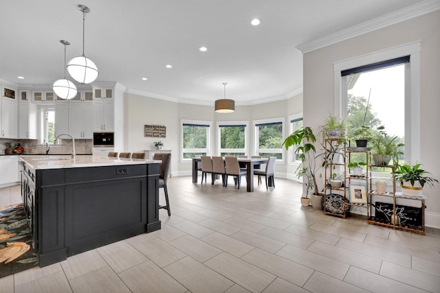 7074 S Ainger Rd, Olivet, MI 49076 - kitchen with healthy amount of natural light, white cabinetry, glass insert cabinets, backsplash, and recessed lighting