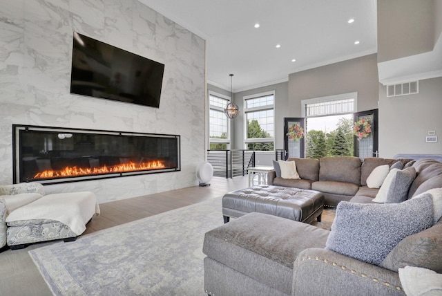 7074 S Ainger Rd, Olivet, MI 49076 - living area featuring crown molding, wood finished floors, a fireplace, recessed lighting, and a high ceiling