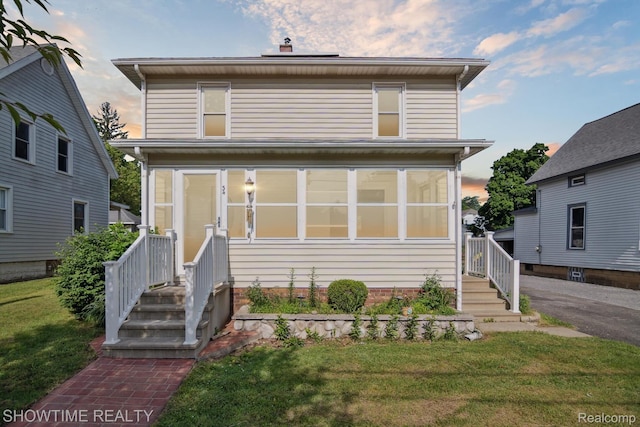 34 Charles St, Hillsdale, MI 49242 - traditional style home with a front lawn and a sunroom